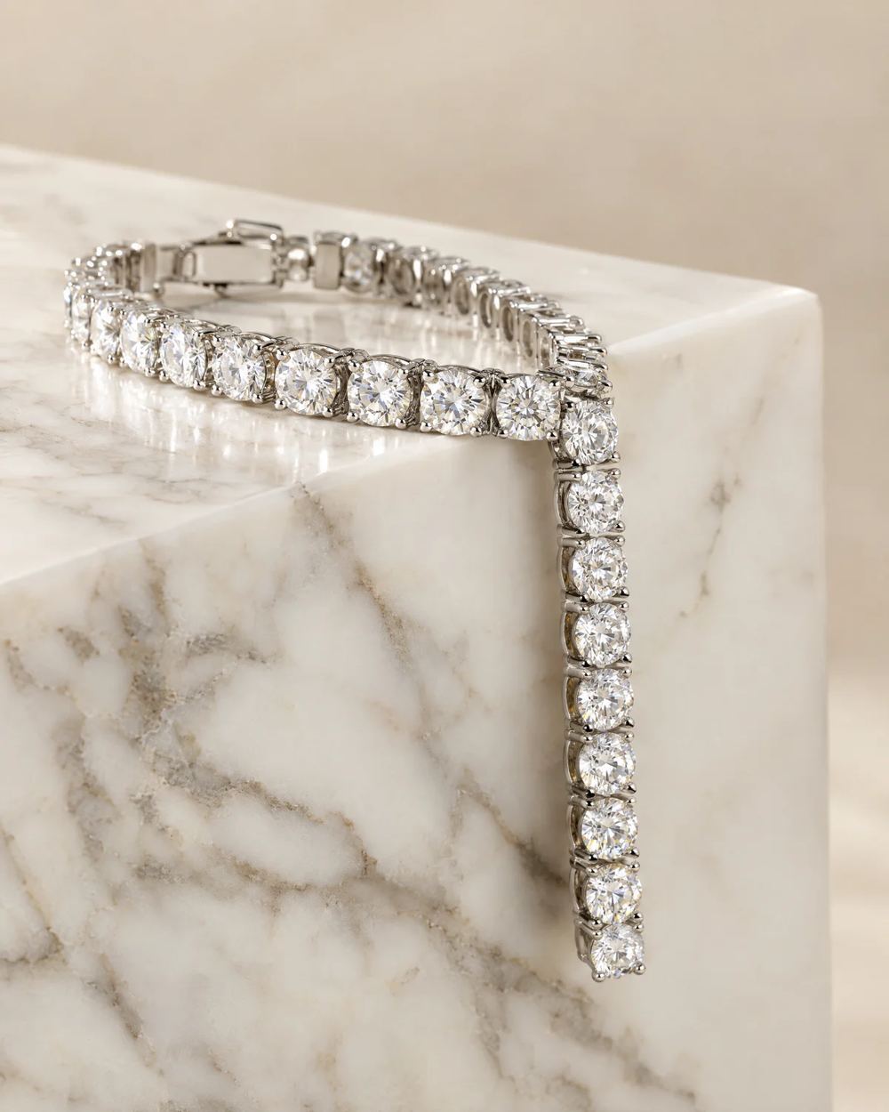 White gold diamond tennis bracelet draped over white marble